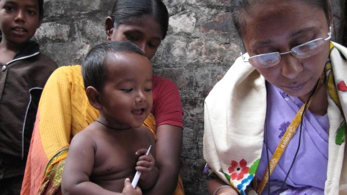 孟加拉国的三个孩子看着护士记录给药