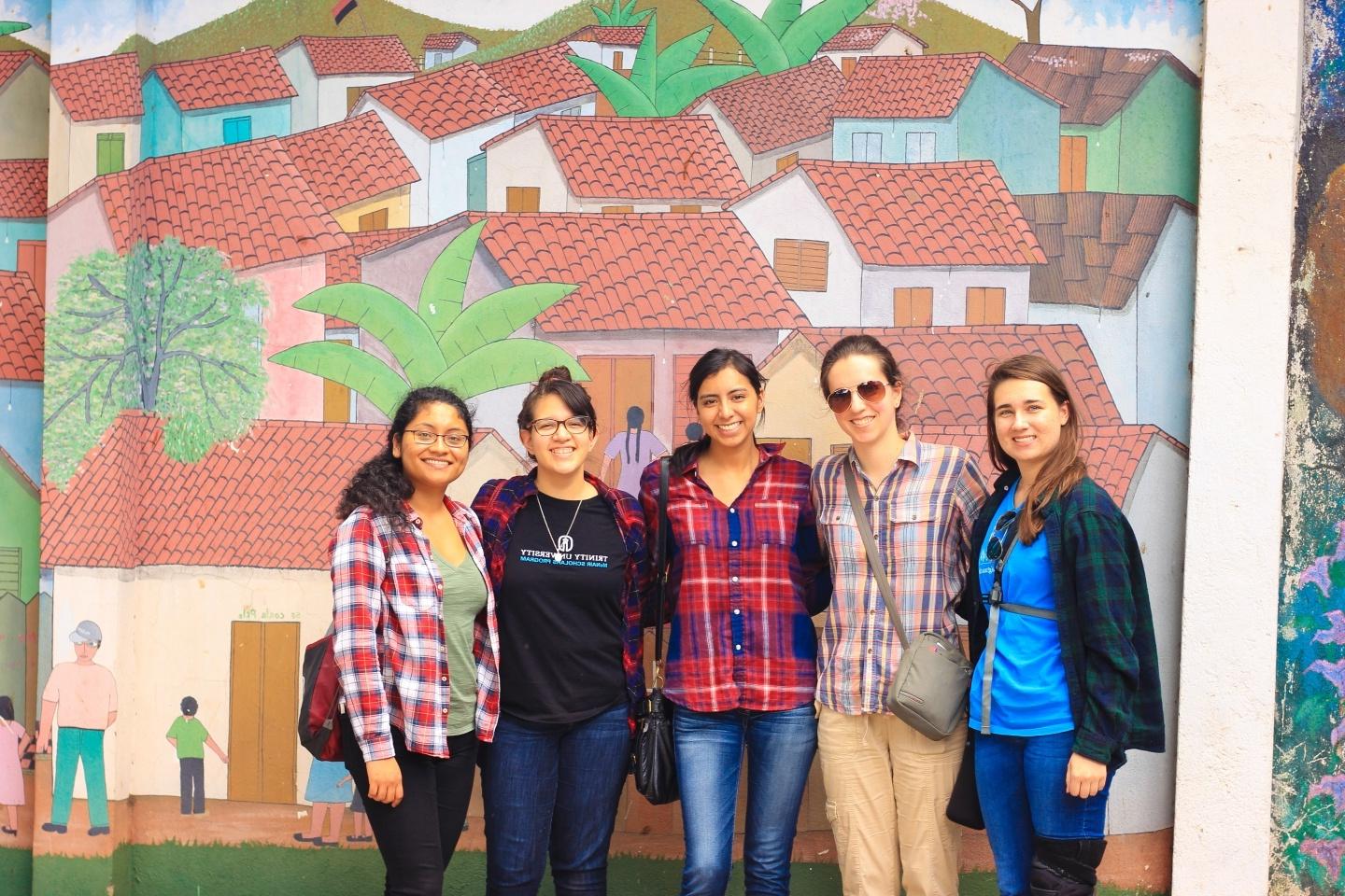 students in front of a mural